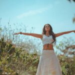 Peaceful scene of a woman meditating outdoors in a sunny summer setting, embodying wellness and tranquility.