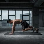 Fit man doing mountain climbers exercise inside a modern gym