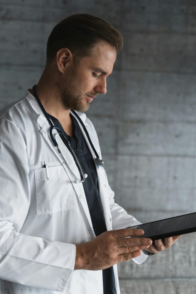 Portrait of a confident male doctor using a tablet indoors.